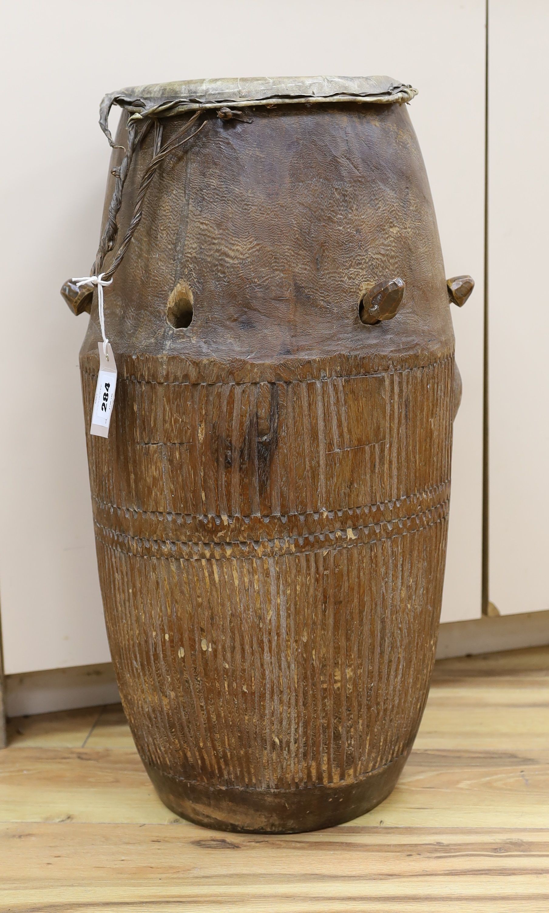 A 19th/20th century Ashanti breasted drum, 61 cms high.